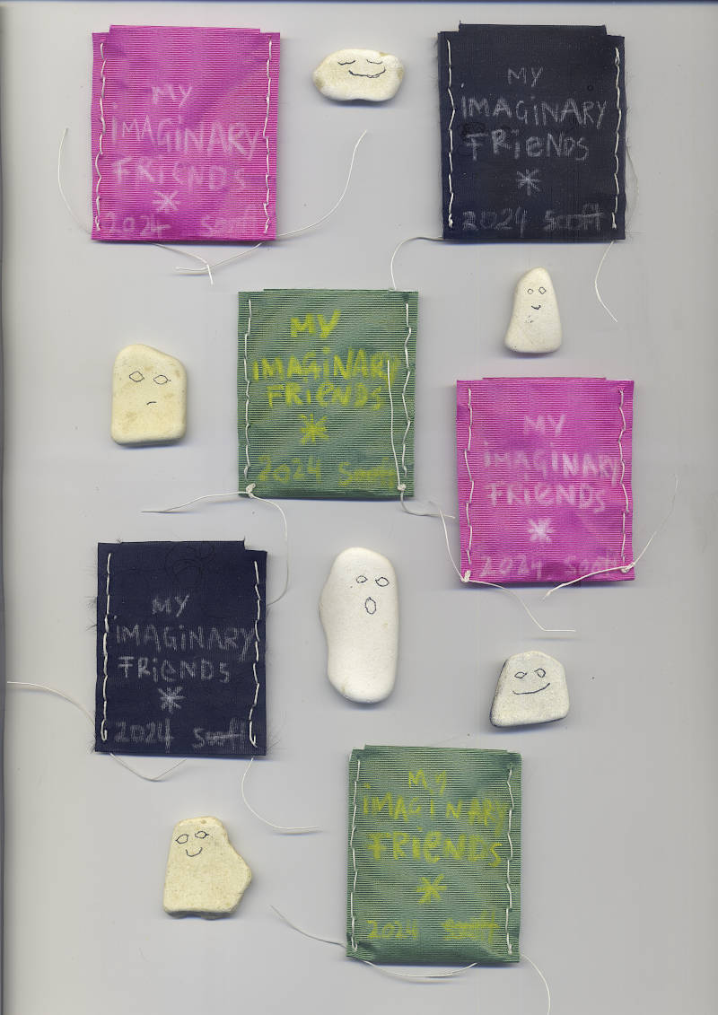 Small satin paper envelopes, handsewn, title written with white pencil. Inside the envelopes are ceramic fragments collected in a small river. Friendly faces are drawn with charcoal on them, so they resemble friendly ghosts.