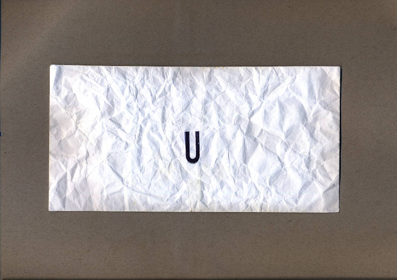 A crumpled white envelope with the letter U stamped on it