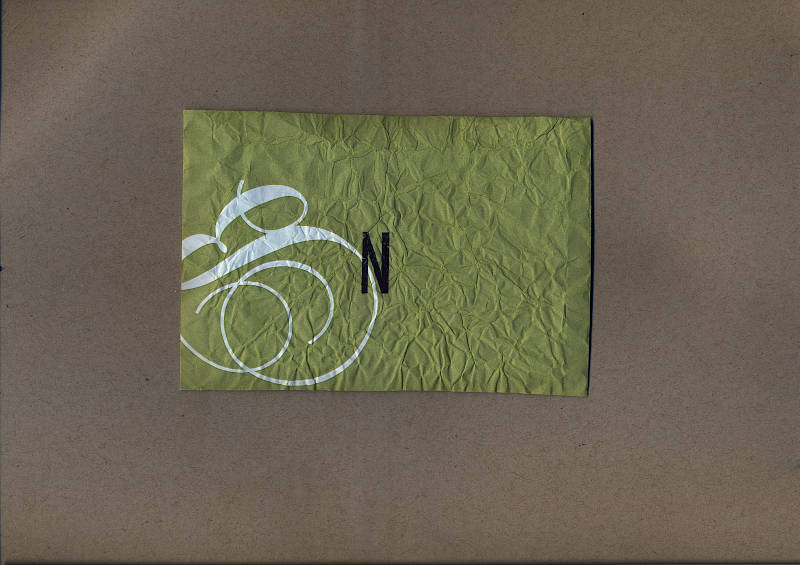 A crumpled green envelope with the letter N stamped on it