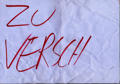 piece of paper with handwritten words “Zu Versch…” (Give Aw…), word ends abruptly