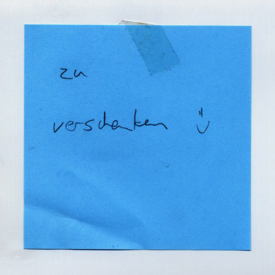 piece of paper with handwritten words “Zu Verschenken” (Give Away), and a narrow smiley face