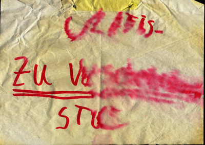 a weathered piece of paper with handwritten words “Zu Verschenken” (Give Away)