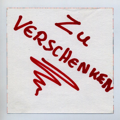 piece of paper with handwritten words “Zu Verschenken” (Give Away), and a swoosh underline